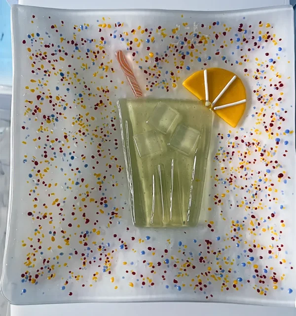 Colorful celebration-themed platewith a refreshing glass of lemonade garnished with a straw and a slice of lemon, inviting a cheerful toast to summer days. Made at Glass Duchess Studio in Port Charlotte, FL