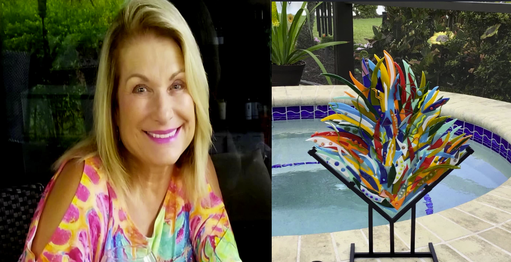 Smiling woman next to a colorful glass sculpture by a pool.